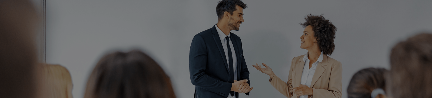 Hero (22) Two person presenting something towards co-workers